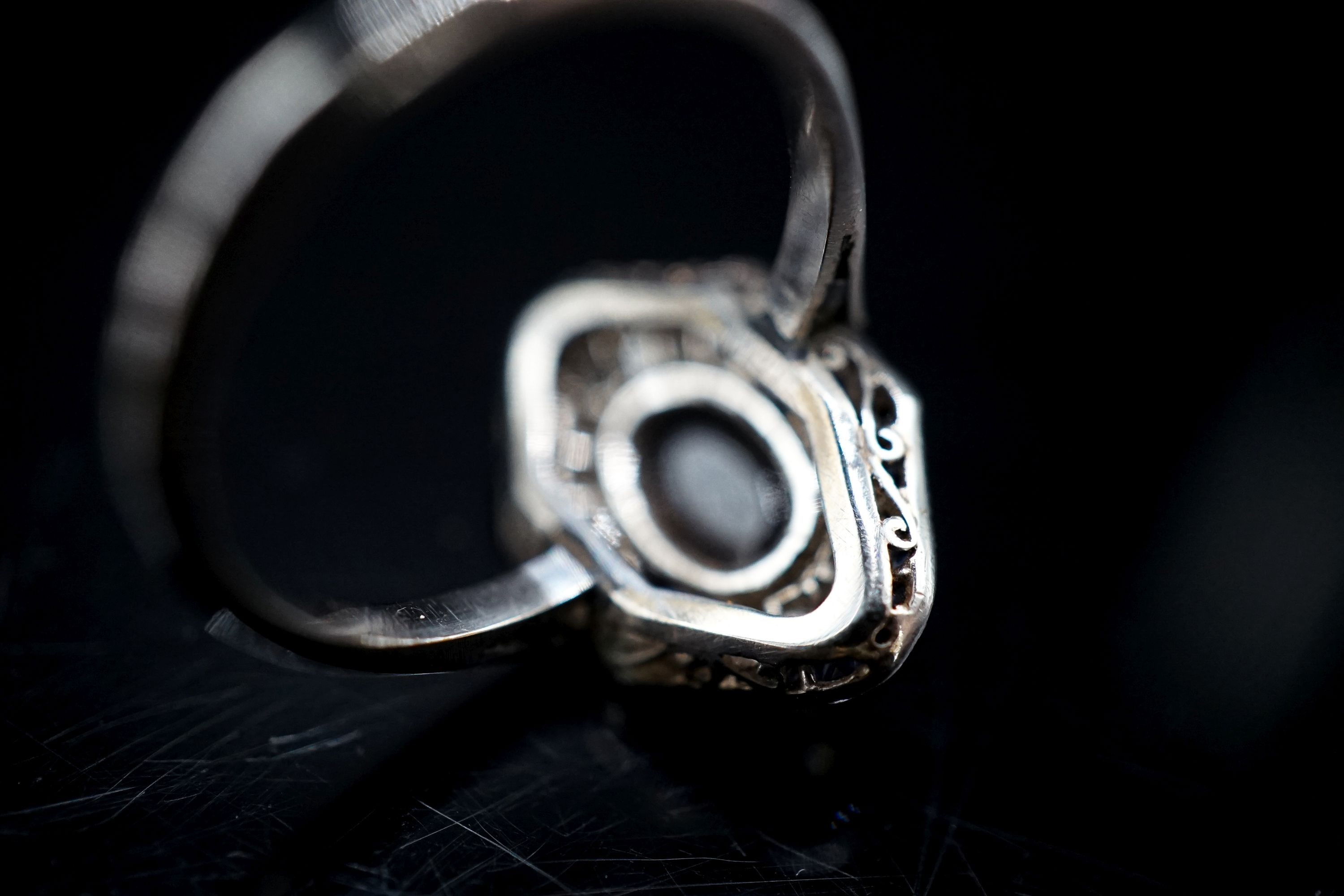 A 1920's white metal (stamped plat), sapphire and diamond ring, with central cabochon sapphire, size M, gross weight 4.6 grams.